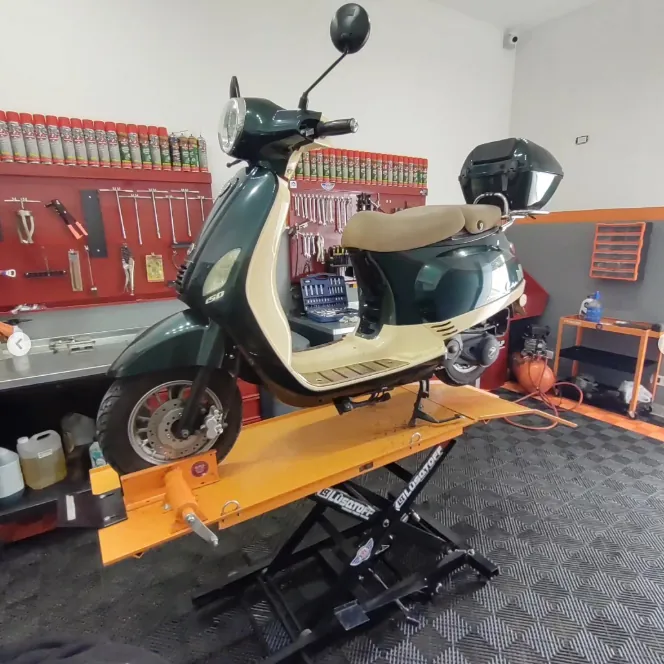 Moto sobre elevador hidráulico en el taller Motos Roll
